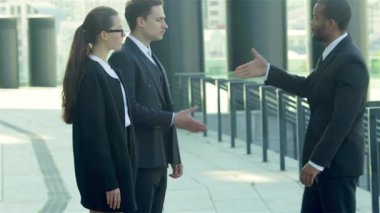 Konuksever yeni ortaklar. İş adamları resmi elbise sokakta buldum gülen grubu. İş ilişkileri.