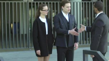 Konuksever yeni ortaklar. İş adamları resmi elbise sokakta buldum gülen grubu. İş ilişkileri.