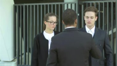 Konuksever yeni ortaklar. İş adamları resmi elbise sokakta buldum gülen grubu. İş ilişkileri.