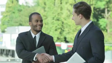 Konuksever yeni ortaklar. İş adamları resmi elbise sokakta buldum gülen grubu. İş ilişkileri.