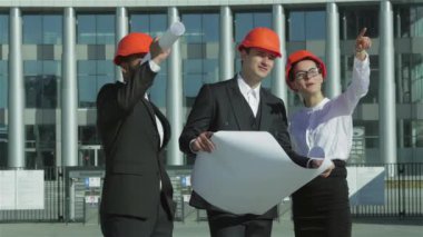 Üç emin iş koruyucu kask ayakta sitede mimar ve nesneyi görüntüleme. En iyi fikirler bina.