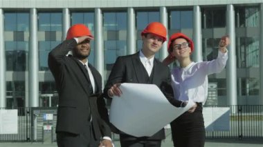 Üç emin iş koruyucu kask ayakta sitede mimar ve nesneyi görüntüleme. En iyi fikirler bina.