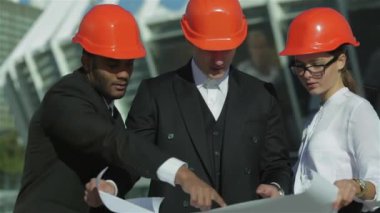 Üç emin iş koruyucu kask ayakta sitede mimar ve nesneyi görüntüleme. En iyi fikirler bina.