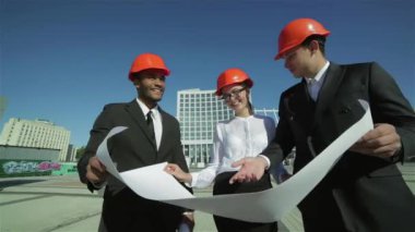 Üç emin iş koruyucu kask ayakta sitede mimar ve nesneyi görüntüleme. En iyi fikirler bina.