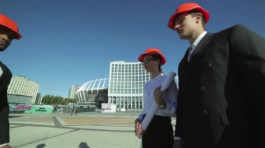 Üç emin iş koruyucu kask ayakta sitede mimar ve nesneyi görüntüleme. En iyi fikirler bina.