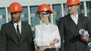 Üç emin iş koruyucu kask ayakta sitede mimar ve nesneyi görüntüleme. En iyi fikirler bina.