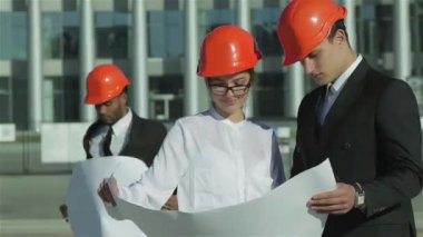 Üç emin iş koruyucu kask ayakta sitede mimar ve nesneyi görüntüleme. En iyi fikirler bina.