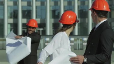 Üç emin iş koruyucu kask ayakta sitede mimar ve nesneyi görüntüleme. En iyi fikirler bina.