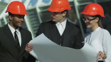 Üç emin iş koruyucu kask ayakta sitede mimar ve nesneyi görüntüleme. En iyi fikirler bina.