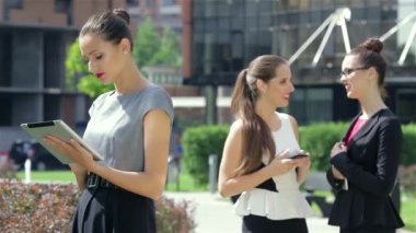 Ortak iş iletişimi. Genç çekici iş kadını ofis dışında duruyor.