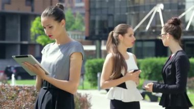 Ortak iş iletişimi. Genç çekici iş kadını ofis dışında duruyor.