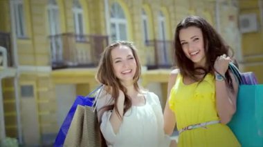 Kızlar alışveriş tutan çantalar ve dükkan yürümek. Gülümseyen kız birlikte eğleniyor.