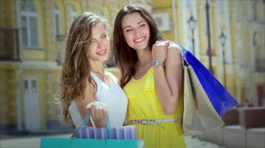 Kızlar alışveriş tutan çantalar ve dükkan yürümek. Gülümseyen kız birlikte eğleniyor.