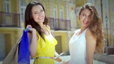 Kızlar alışveriş tutan çantalar ve dükkan yürümek. Gülümseyen kız birlikte eğleniyor.