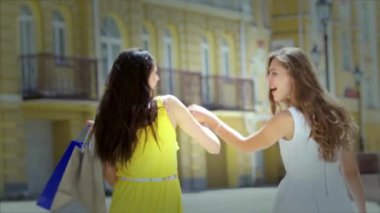 Kızlar alışveriş tutan çantalar ve dükkan yürümek. Gülümseyen kız birlikte eğleniyor.