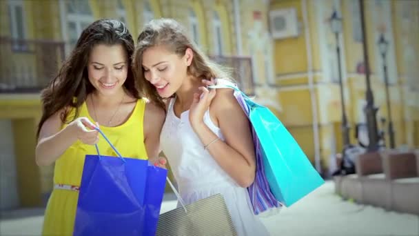 女孩抱着购物袋 走在商店周围 小女孩微笑着让大家一起开心 — 图库视频影像