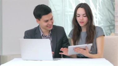 Genç çekici iş erkek ve kadın harmanlama veri tablet üzerinde tartışıyor