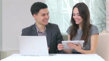 Genç çekici iş erkek ve kadın harmanlama veri tablet üzerinde tartışıyor