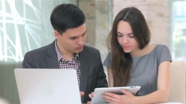 Genç çekici iş erkek ve kadın harmanlama veri tablete kamera slayt tartışıyor