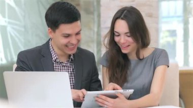 Genç çekici iş erkek ve kadın harmanlama veri tablete kamera slayt tartışıyor