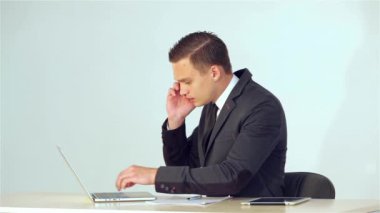 Telefonla konuşan bir defter notları genç işadamı veri içinde belgili tanımlık laptop sonra yapmak yapar