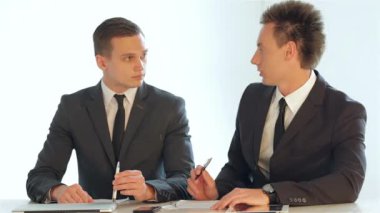 İş tartışırken bir masada oturan işadamları holding kalem el planı