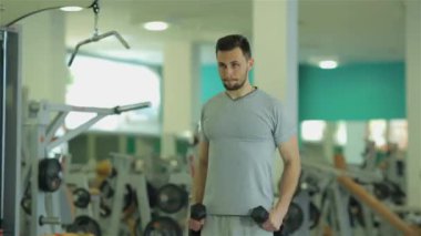 Pazı ve triceps için dumbbells ile egzersiz yaparak genç adam