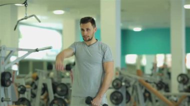 Egzersiz 2 triceps için dumbbells ile yapan genç erkek