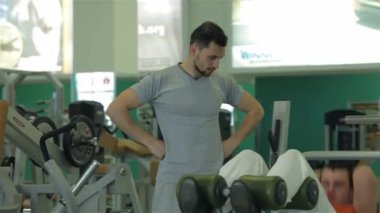 Fitness Eğitmeni genç bir adam nasıl bir egzersiz karın kasları için yapılacağını gösterir.