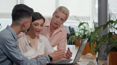 Dinamik bir iş ekibi, yaratıcı meslektaşlarına rehberlik eden olgun bir iş kadınıyla gösterişli bir toplantı odasında projelerini tutkuyla tartışıyor. Atmosfer yenilikle yüklü.