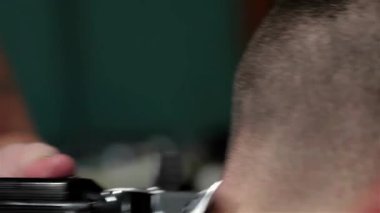 Hareketli bir berber dükkanında, yetenekli bir berber yakışıklı bir adamın boynunu ustalıkla tıraş eder, tımar sanatını sergiler. Atmosfer makasın uğultusu ve taze kokuyla dolu.