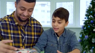 Çekici esmer bir çocuk oyuncağı tarafından büyülenir. ATV 'nin izini sürüp masayı ustalıkla manevra ettirir. Onun özenli Afrikalı Amerikalı babası gururla gülümseyerek, iç açıcı bir sahne yaratıyor