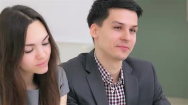Genç, çekici bir çift, şık takım elbiseli bir adam ve uzun saçlı bir kadın, bir iş tartışmasında, takım çalışması ve işbirliği gösteriyorlar. Odaklanmış ifadeleri ve...