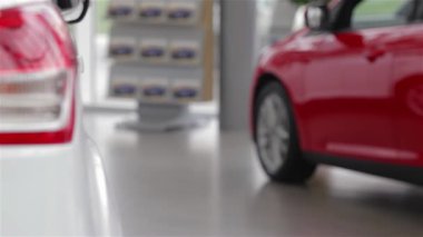 Rahat bir süveter giyen şık bir genç kadın modern bir bayilikte şık bir model arabayı inceleyerek otomotiv seçimlerine olan hevesini gösteriyor. Sergi salonunun canlı atmosferi...