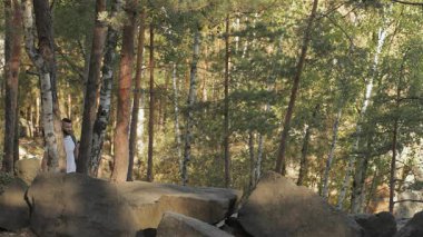 Zinde bir çift bereketli yeşilliklerle çevrili engebeli kayaların üzerinden neşeli bir tırmanışa girişiyor. Sakallı beyaz adam, esmer kız arkadaşının kafasını öpüyor ve bağlarını gösteriyor.