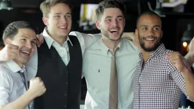 Canlı bir barda heyecanlı bir futbol maçı izlerken aynı anda sevinç, tezahürat ve bağrışma dolu dört genç iş adamı. Yoldaşlıkları bira kadehlerini kaldırırken parlıyor.