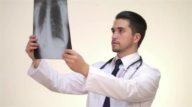 Gıcır gıcır beyaz bir tıp elbisesi giyen kendini işine adamış bir erkek doktor, özenle akciğerlerinin röntgenini çekiyor ve hasta bakımına olan bağlılığını gösteriyor. Sahne, bu işin profesyonelliğini vurgulayan yumuşak, tarafsız bir altyapıyla geliştirilmiştir.