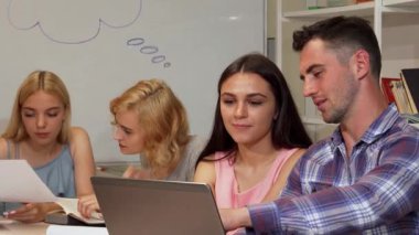 Yakışıklı bir genç erkek öğrenci ve onun gülümseyen bayan arkadaşı parlak bir kampüs kütüphanesinde odaklanmış sınıf arkadaşları tarafından laptopları üzerinde çalışırken canlı bir tartışmaya girişirler. Bu canlı sahne takım çalışmasının ve akademik çalışmanın özünü yansıtıyor.