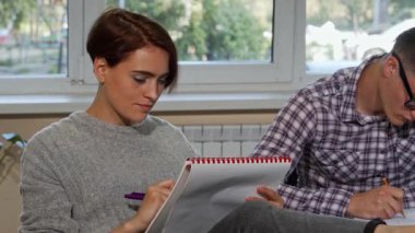 Kameraya kısa siyah saçlı parlak ve neşeli bir üniversiteli kız derslerine odaklanmış bir erkek sınıf arkadaşıyla dalmış. Doğal ışık ile dolu rahat kütüphane ortamı, onun gibi ilham ve öğrenme atmosferini geliştirir.