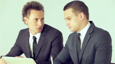 Odaklanmış bir işadamı, yenilikçi iş planını bir yoldaşa tutkuyla dile getirerek, dinamik bir fikir alışverişi sergiliyor. Modern dekor ve masadaki dizüstü bilgisayarla gösterişli ofis ortamları profesyonel atmosferi arttırıyor.