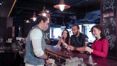 İki neşeli kız ve bir erkeğin uzun bir günün ardından yoldaşlığı kutlamak için kalabalık bir barda içkileriyle kadeh kaldırdığı canlı bir sahne başlıyor. Atmosfer heyecan verici, kahkahalarla dolu ve kadehlerin şıngırtıları, onlar için tezahürat yaparken