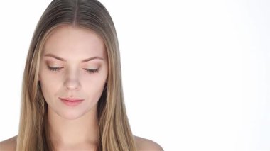 Bu büyüleyici portre, beyaz arka planda duran, uzun, dalgalı sarı saçlı ve parlak tenli, güzel beyaz bir kadını gösteriyor. Onun nazik gülümsemesi ve yumuşak bakışları güzelliğin ve tenin özünü somutlaştıran hayranlığı davet ediyor.