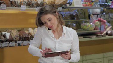 Gıcır gıcır beyaz tişörtlü, genç, neşeli beyaz bir kadın fırından telefon siparişi alıyor, gülümsemesi sıcacık yayılıyor. Kahverengi saçlarıyla ustalıkla dijital tablete yazı yazıyor, baştan çıkarıcı bir ekran ile çevrili.