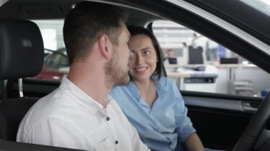 Genç bir çift, gülümseyen beyaz bir erkek ve kadın galerideki gösterişli bir arabanın içinde samimi bir sohbete girişiyor. Hayallerindeki aracı satın alma olasılıklarını keşfederken gözleri bir bağlantı anına kilitlenir.