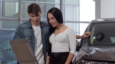 Genç ve neşeli bir çift galeride lüks bir otomobilin yanında duruyor, bilgi kağıdını hevesle okuyorlar. Güzel kadın ve yakışıklı erkek arkadaşı, gelecekteki maceralarını bu yeni araçla hayal ederken gülümsüyorlar.