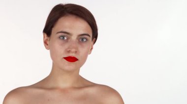 Çekici, kırmızı dudaklı esmer bir kadın incelikle kameraya bakar, zarafet ve güven saçar. Bu stüdyo, kusursuz cildini ve zarif duruşunu, saf beyaz bir arka plana karşı sergiliyor. Güzellik ve cilt bakımı için mükemmel.