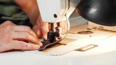 Odaklanmış olgun bir kunduracı atölyesindeki eski bir dikiş makinesinin iğnesinin altında deriyi ustalıkla idare eder. Bu büyüleyici sahne el yapımı ayakkabıların ustalığını ve hassasiyetini ön plana çıkarıyor. Geleneksel bir güzelliği gözler önüne seriyor.