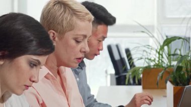 Kesilmiş bir çekim, canlı bir tartışmaya katılan dinamik bir iş ekibini, çeşitli genç meslektaşlarına rehberlik eden olgun bir kadın CEO 'yla yakalar. Atmosfer yaratıcılık ve takım çalışması ile doludur, çünkü modern ofis alanlarında sezgileri paylaşırlar.