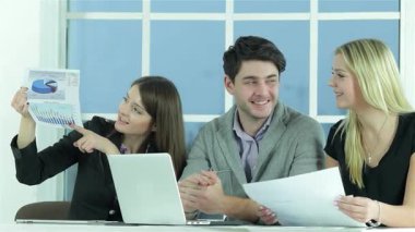 Neşeli bir işadamı ve odaklanmış bir proje yöneticisi renkli bir raporu analiz ederek dinamik bir tartışmaya girişirler. Sahne, geniş bir alana yayılan parlak doğal ışık filtresiyle çevrili bir dizüstü bilgisayarın üzerinde iş birliği yaparken coşkularını yakalıyor.