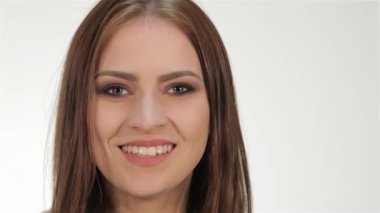 Hoş bir süveter giyen çarpıcı genç bir kadın barış işareti gösterirken pozitiflik saçıyor. Parlak gülüşü çerçeveyi aydınlatıyor. Temiz beyaz bir arkaplana sahip, neşeli tavırları neşe ve bağlantıyı davet ediyor, uyum ruhunu somutlaştırıyor.